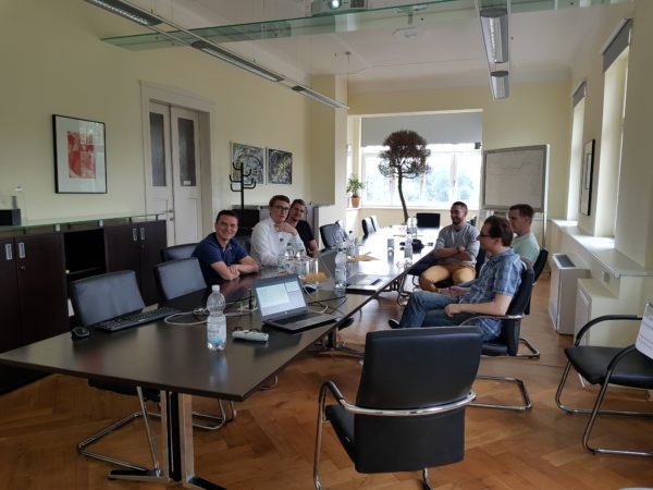 Mehrere Personen sitzen an einem langen Tisch im Konferenzraum