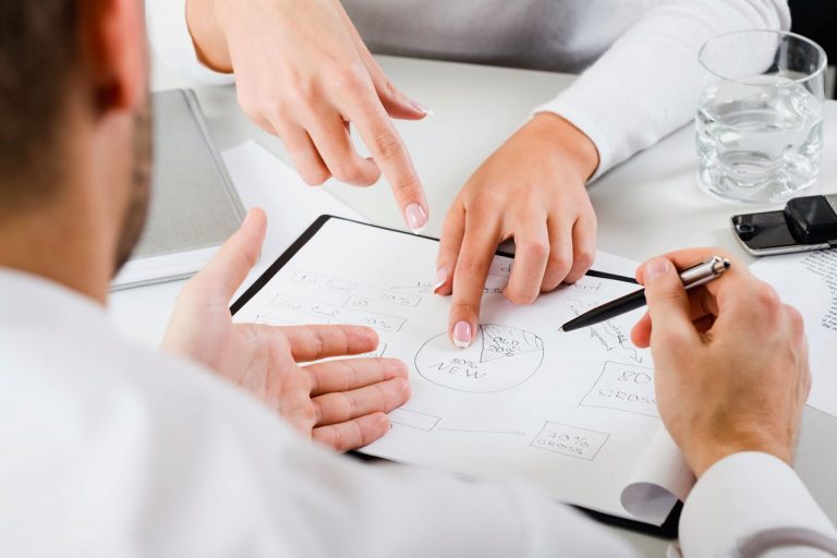 Two people sitting at a table, dicussing 