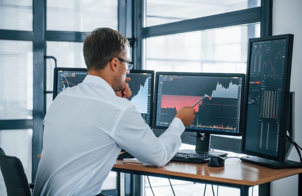 Data scientist in front of monitor with graphs