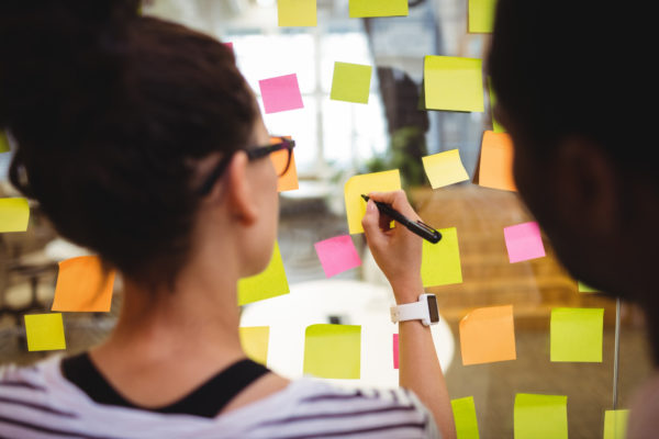 Person is writing on coloured sticky notes